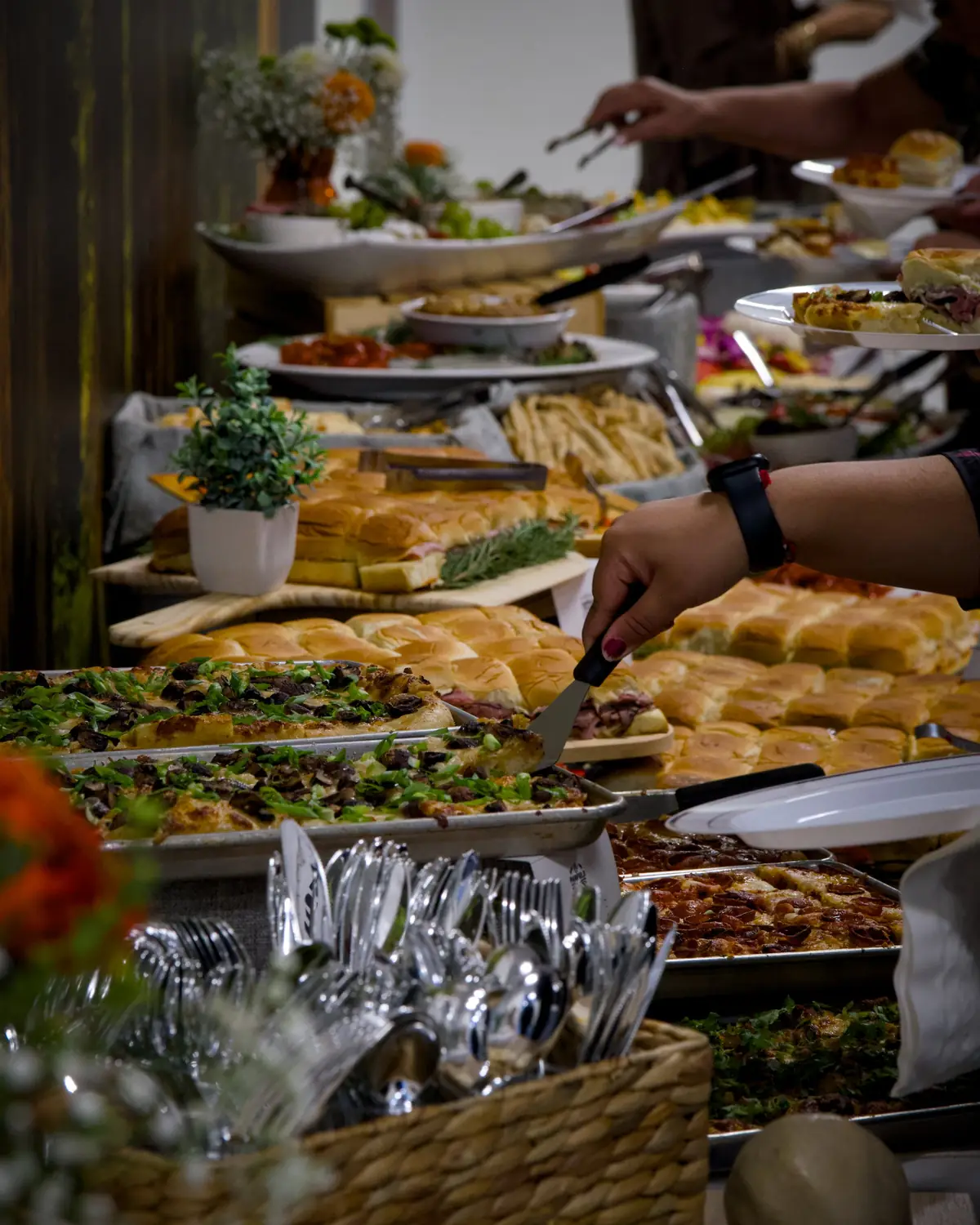 Guests serving themselves grandma pizza and sliders at a Pairfield Pizza & Pints catered buffet